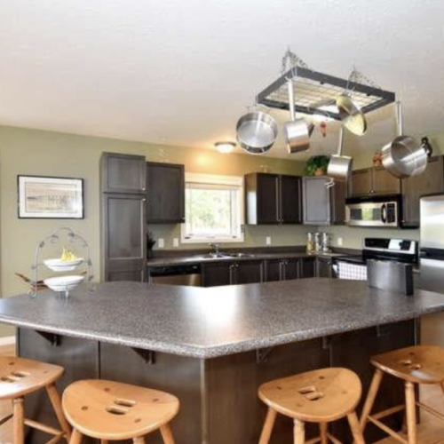 The inviting kitchen island is your hub for morning chatter and evening feasts, all with a side of stunning lake views.