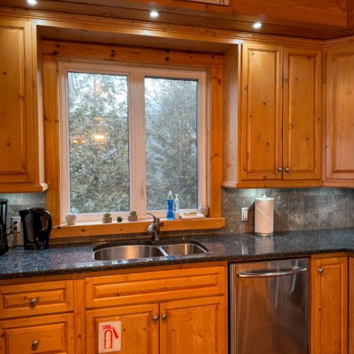 Bright kitchen with lake views and rustic charm—perfect for cooking, relaxing, and enjoying cozy cottage getaways or lakeside vacations.