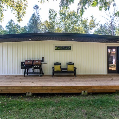 Covered deck area with BBQ and seating for outdoor meals and sunset dinners.