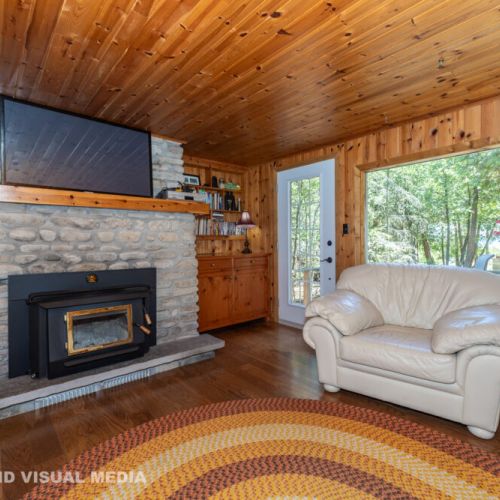 Warm, wood-lined interior with a beautiful stone chimney — the true northern-Ontario cottage feeling.