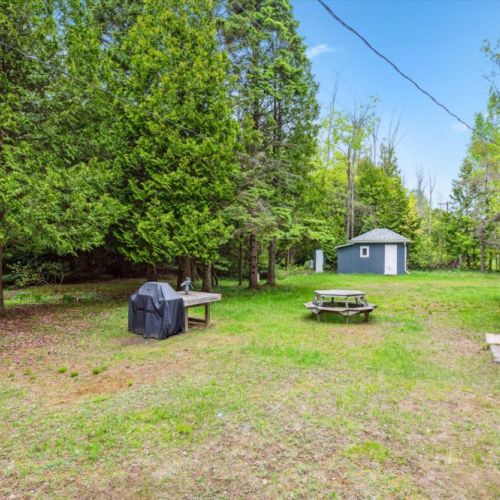The main entrance side is welcoming but unpretentious — just what you’d expect from a rustic cottage. A couple of chairs invite you to sit with a cool drink while dinner cooks on the grill nearby.