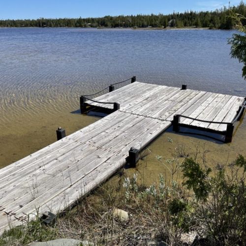 Dock extending into calm, shallow waters