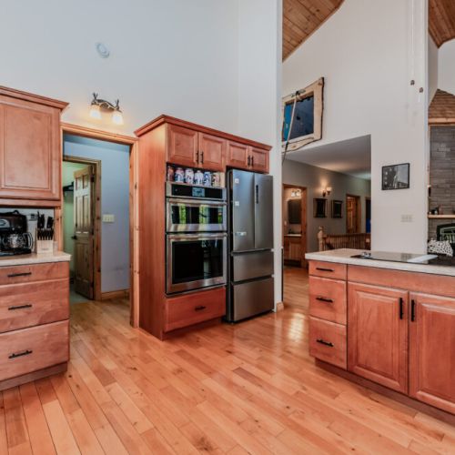 Double oven and sleek fridge in a kitchen that blends function with rustic charm.