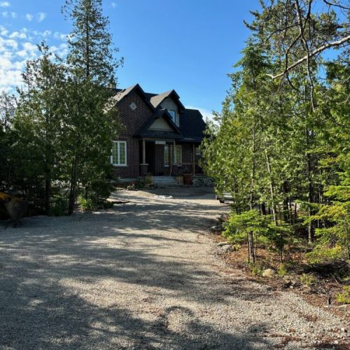 Private driveway and front view of The Brick House, offering privacy and a peaceful arrival surrounded by nature