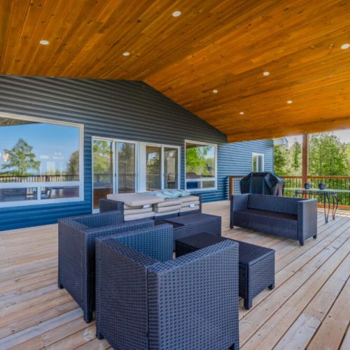 Relax in style on this spacious covered patio, complete with modern outdoor furniture. Perfect for dining alfresco or enjoying a serene evening under the stars.