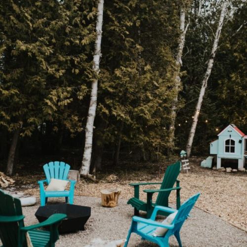 Gather around the firepit with comfortable Muskoka chairs nestled in a quiet forest setting.
