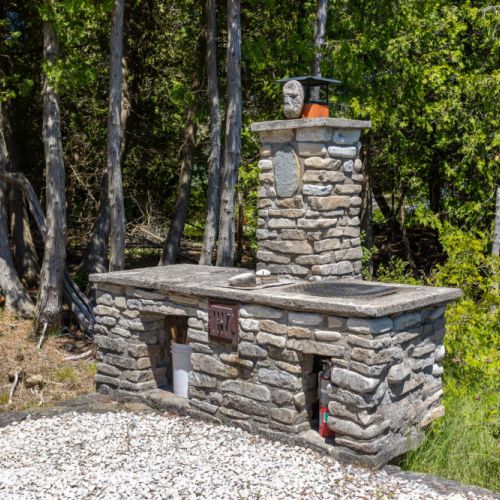 Beautiful custom stone outdoor fireplace area for cozy evenings by the bay.