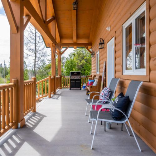 The welcoming front porch is adorned with comfortable seating and charming decor, inviting guests to sit back and enjoy the tranquility of Pike Bay.