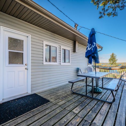 A closer look at the deck area with the lake visible in the background, creating a serene setting for dining or lounging.