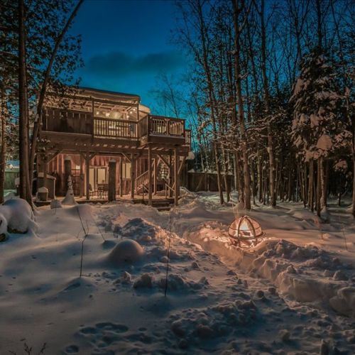 Cozy winter nights at the shared cabin with soft lighting and a forest backdrop. A magical setting for quiet evenings and stargazing.