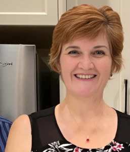 Teresa in floral top, kitchen background.